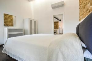 a white bedroom with a large white bed in it at Loft In The Old Town in Alghero