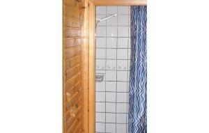 a bathroom with a shower with blue and white tiles at Nice Home In Blomstermåla With Sauna in Barnebo