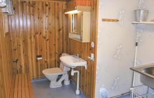 a wooden bathroom with a sink and a toilet at Lovely Home In Blomstermla With Kitchen in Barnebo