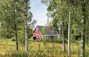 a red house in a field with trees at Nice Home In Lenhovda With Wifi in Möcklehult