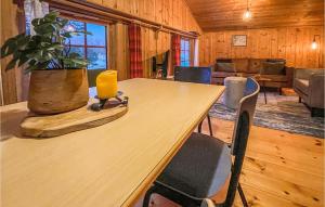 een houten tafel met stoelen en een potplant in een kamer bij Gorgeous Home In Ringebu With House A Mountain View in Odlo