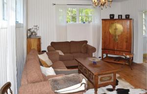 ビンメルビューにあるBeautiful Home In Vimmerby With 3 Bedrooms, Sauna And Wifiのリビングルーム(ソファ、テーブル付)