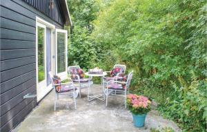 een patio met stoelen, een tafel en bloemen bij Het Appelhuisje in Wijdenes