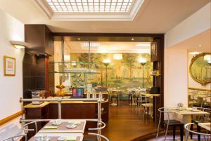 a restaurant with tables and chairs and a window at Hôtel du Levant in Paris