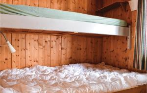 een bed in een kamer met houten wanden en een stapelbed bij Stunning Home In Sjusjen With Kitchen in Sjusjøen