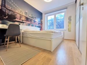 a bedroom with a bed and a desk and a window at Scandian Apartments - City Hub Tallinn in Tallinn