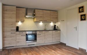 a kitchen with wooden cabinets and a stove top oven at Oud Kempen Bungalow 173 in Stavenisse