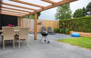 a patio with a grill and chairs and a fence at Oud Kempen Bungalow 173 in Stavenisse
