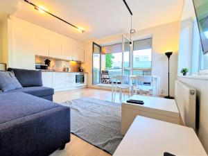 a living room with a couch and a kitchen at Scandian Apartments - City Hub Tallinn in Tallinn