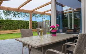 a wooden table with chairs and flowers on a patio at Oud Kempen Bungalow 173 in Stavenisse
