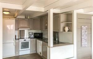 una cocina con armarios blancos y electrodomésticos blancos en Awesome Home In Mandal With Kitchen, en Mandal