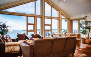 a living room with a couch and a large window at Nice Home In Nedstrand With Sauna in Nedstrand