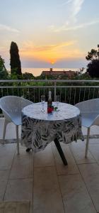 a table with two chairs and a bottle of wine at Apartments Mirjana in Piran