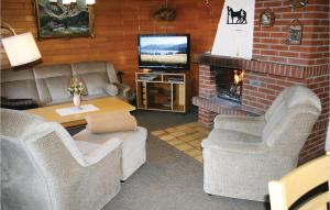 un soggiorno con divani, TV e camino di Lovely Home In Oberaula-hausen With Wifi a Hausen