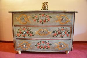 a dresser with a painting of flowers on it at Hotel Aquamarin in Bad Mitterndorf