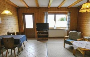 a living room with a table and a television at Cozy Apartment In Grfendorf With House A Panoramic View in Gräfendorf