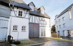 a white and red house with a red garage at Two-Bedroom Holiday Home In Hachenburg in Hachenburg