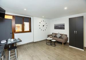 a living room with a couch and a clock on the wall at Xoel in Muxia