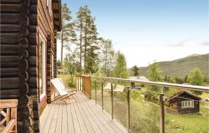 SlettmoenにあるAmazing Home In Heidal With 5 Bedrooms And Saunaの木製デッキ(家の横に椅子付)