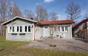 una piccola casa bianca con tavolo e sedie di Amazing home in Ljungby with 3 Bedrooms and WiFi a Ljungby