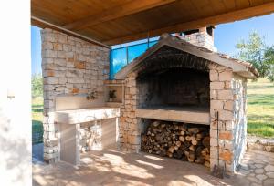 an outdoor oven with a pile of fire wood at House Marina in Postira