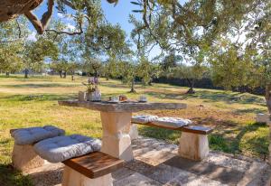 a picnic table and two benches in a park at House Marina in Postira
