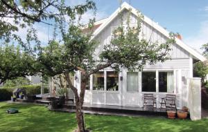 a white house with a tree in the yard at Nice Home In Vstra Frlunda With Wifi in Gothenburg