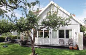 een wit huis met een boom in de tuin bij Beautiful Home In Vstra Frlunda With 3 Bedrooms, Sauna And Wifi in Göteborg