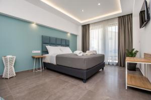 a bedroom with a bed and a blue wall at Azzurro Deluxe in Limenaria