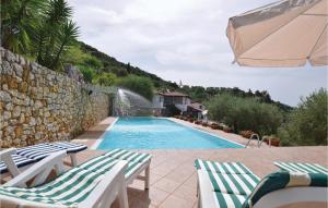 a swimming pool with two lounge chairs and a water fountain at Villa I Cedri in Santa Lucia