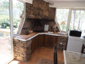 a kitchen with a stone wall and a sink at Villa PINEDE in Porto-Vecchio