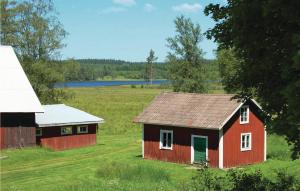 una vieja casa roja y un granero en un campo en Stunning Home In Vrigstad With Wifi en Vrigstad