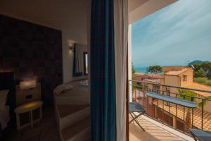 a room with a balcony with a view of the ocean at Hotel Baia Del Capitano in Cefalù