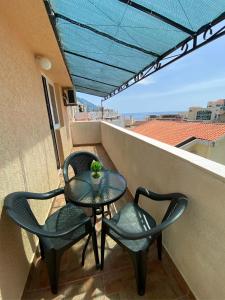 einen Tisch und Stühle auf einem Balkon mit Aussicht in der Unterkunft Alina's apartment in Becici