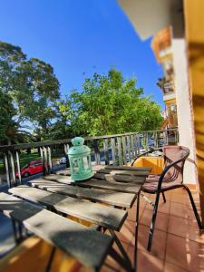 a green vase sitting on a wooden table on a balcony at Aloja Ayamonte in Ayamonte