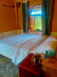 a bedroom with a white bed and a window at H'mông cổ trấn sapa homestay in Sa Pa