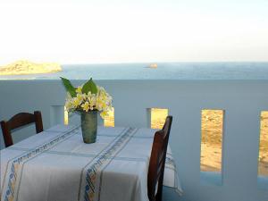 a table with a vase of flowers on top of it at Archipelagos Apartments in Arkasa