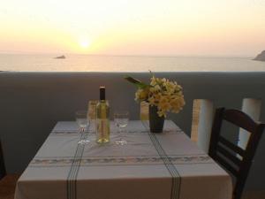a table with a bottle of wine and wine glasses at Archipelagos Apartments in Arkasa