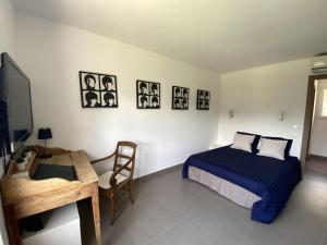 um quarto com uma cama, uma mesa e uma secretária em VILLA Saint Raphael Valescure Piscine Clim Wifi Golf em Saint-Raphaël