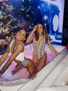 two young women in a hot tub in a swimming pool at LOFT CON SPA PRIVATA in Santa Maria degli Angeli
