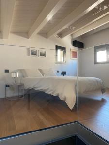 ein großes Bett in einem Zimmer mit einer Glaswand in der Unterkunft Le dimore di Palagonia in Bagheria