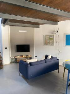 un salon avec un canapé bleu et une télévision dans l'établissement Le dimore di Palagonia, à Bagheria
