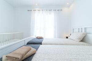 een witte slaapkamer met een groot bed met handdoeken erop bij Apartamento Paraiso de Son Moll in Cala Ratjada