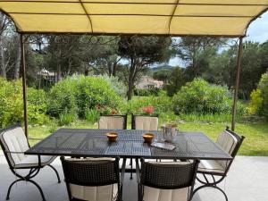 a black table and chairs under a yellow umbrella at VILLA Saint Raphael Valescure Piscine Clim Wifi Golf in Saint-Raphaël