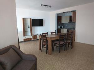 Aura Family Hotel في رافدا: غرفة معيشة مع أريكة وطاولة وكراسي