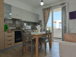 a kitchen with a wooden table and chairs in a room at L’isola di Cristiano Marzamemi in Marzamemi