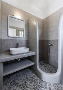 een badkamer met een wastafel en een spiegel bij Pente Elies Milos in Pollonia