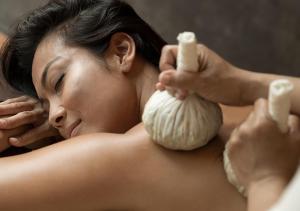 a woman laying in a bath tub holding a peeled onion at Anantara Uluwatu Bali Resort in Uluwatu