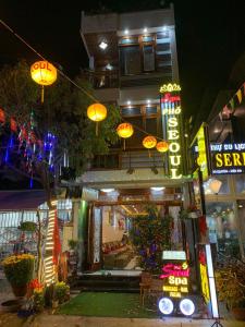 a building with neon signs in front of it at night at Phố Seoul Homestay And Spa in Hoi An