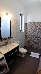 a bathroom with a toilet and a sink and a shower at Villa Miranda in Halki